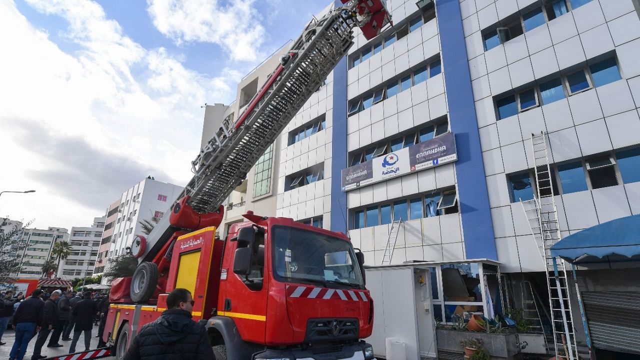 Tunisian firefighters put out a blaze the Islamist-inspired Ennahdha party headquarters in central Tunis on December 9, 2021. Credit: AFP Photo