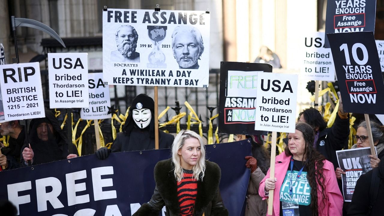 Supporters of Julian Assange display signs and banners, outside the Royal Courts of Justice in London, Britain December 10, 2021. Credit: Reuters Photo