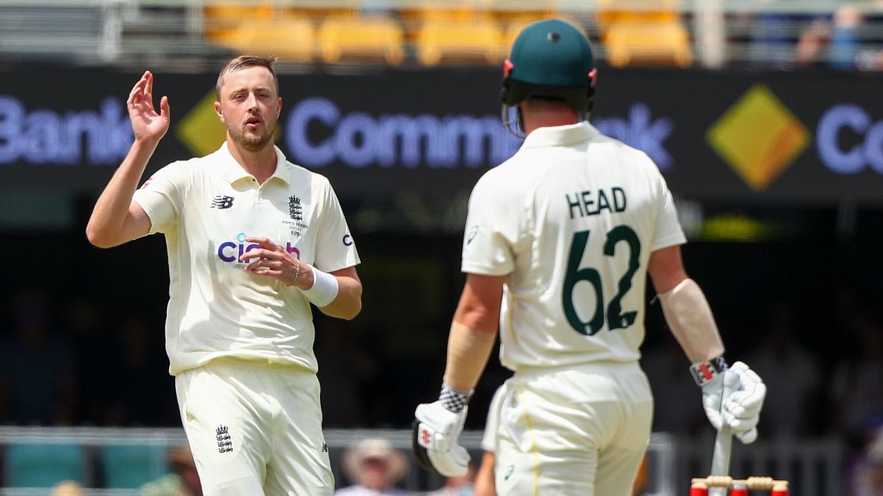 England's Ollie Robinson, left, reacts after bowling to Australia's Travis Head during day three of the first Ashes cricket test at the Gabba in Brisbane. Credit: AP Photo