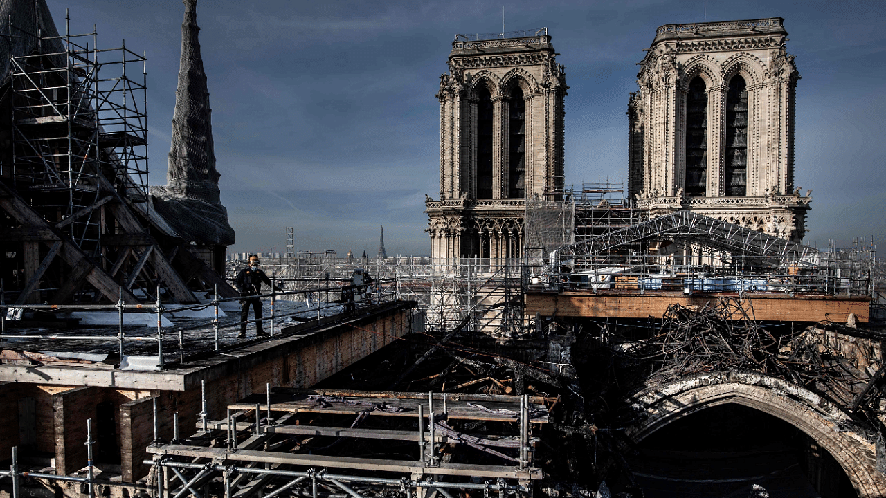 Workers on the roof of Notre-Dame working to remove the burnt scaffolding which hampered the safety of the cathedral damaged by the April 15, 2019 fire in Paris. Credit: AFP Photo