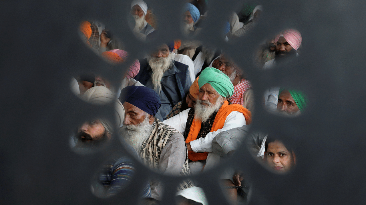 Farmers listen to a speaker at the protest site near the Delhi-Haryana border, India. Credit: Reuters Photo