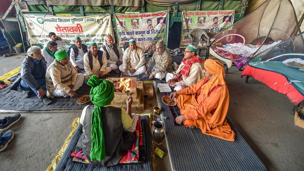 Farmers perform a 'havan' after a decision to withdraw farmers' movement was taken in the wake of the government accepting all their demands, at Ghazipur border, in New Delhi. Credit: PTI Photo