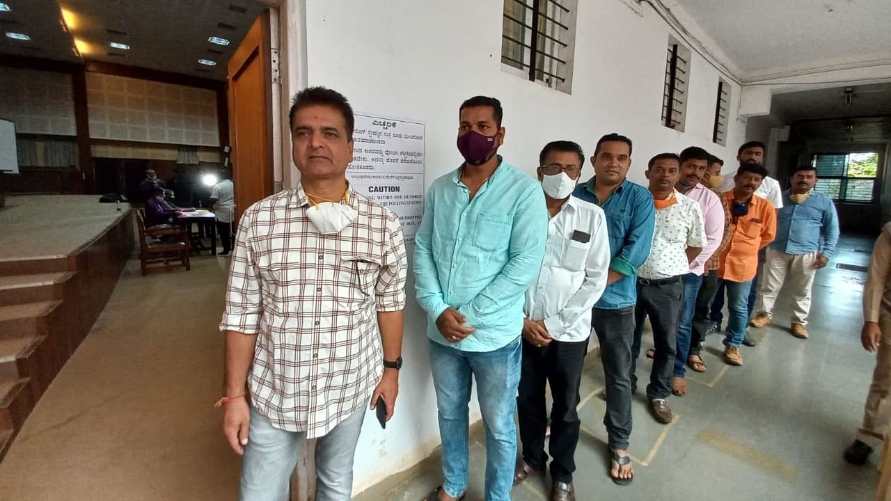 Voters waiting in queue to cast their vote for the election for Legislative Council from Belgaum Local Authorities Constituency at a polling station in Belagavi on Friday. Credit: DH Photo