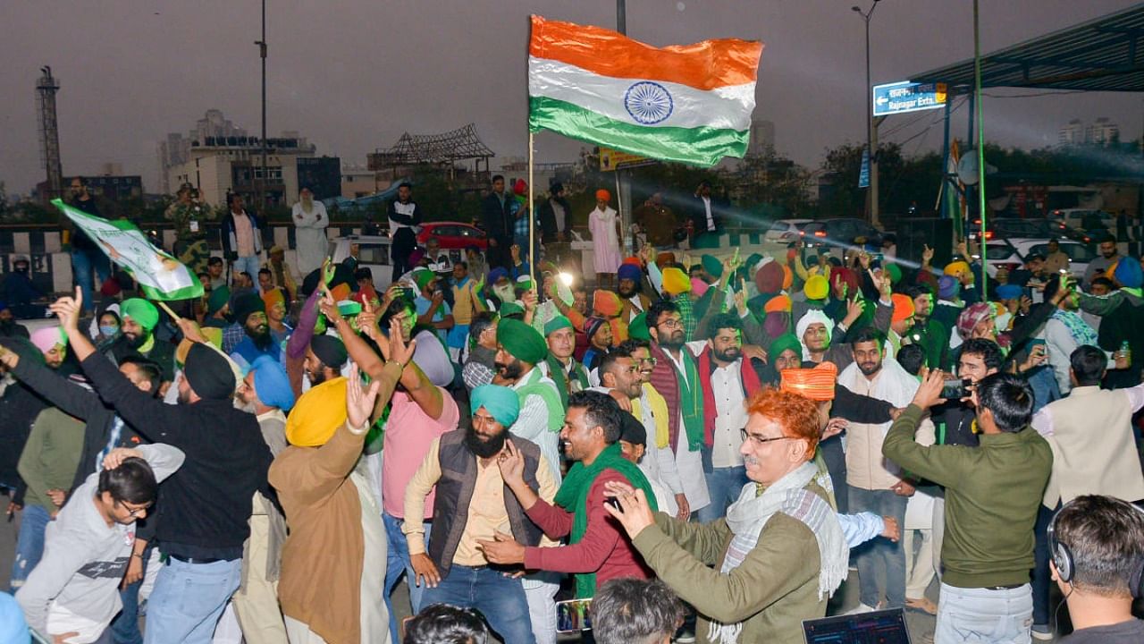 Farmers dance as they celebrate at the Ghazipur border after a decision to withdraw farmers-movement in the wake of the government accepting all demands put forward by the agitating farmers, in Ghaziabad. Credit: PTI Photo