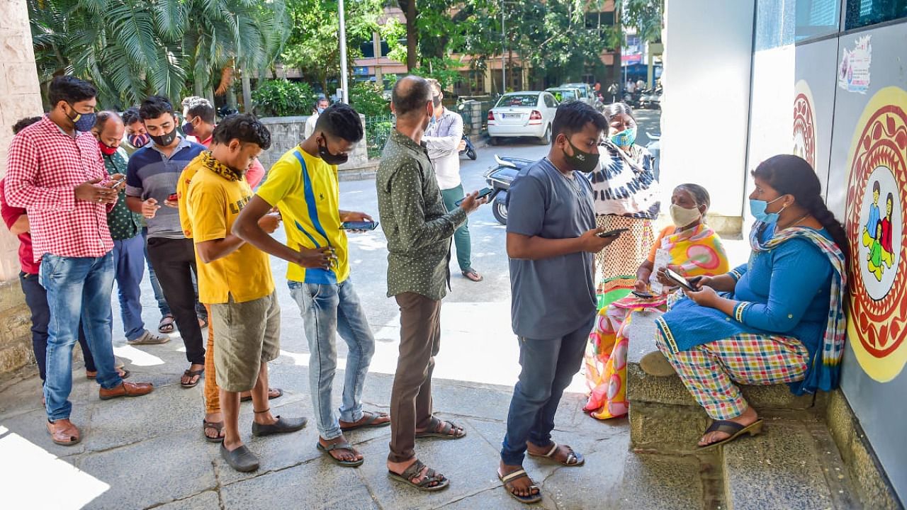 Beneficiaries wait to recieve a dose of Covid-19 vaccine at a government hospital amid fear of spread of 'Omicron variant' in Bengaluru. Credit: PTI Photo