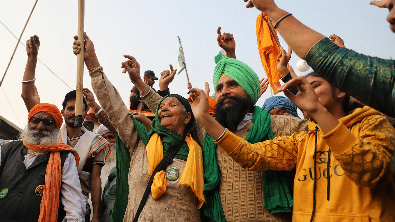 Farmers celebrate following the announcement of suspension of their year-long protest against farm laws & other related issues, at Singhu border. Credit: IANS Photo