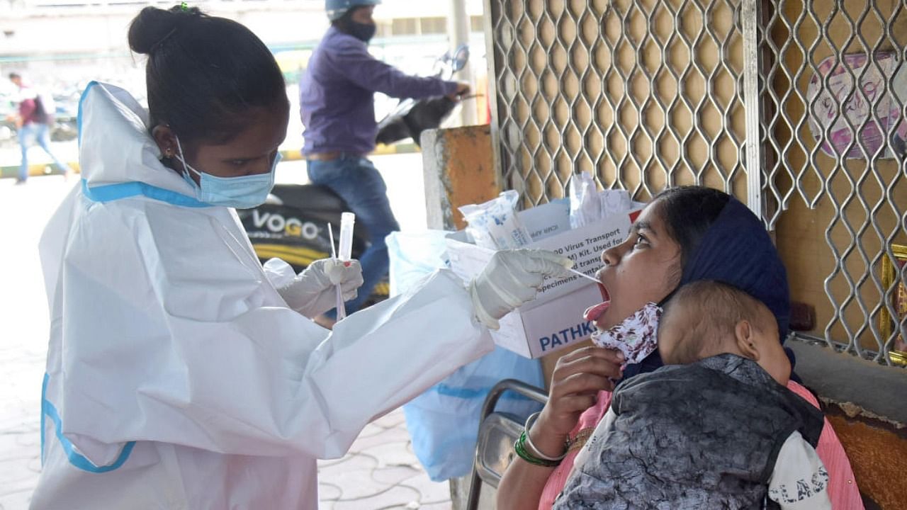 A healthcare worker takes swab samples at the Majestic bus stand. Credit: DH FILE/PUSHKAR V
