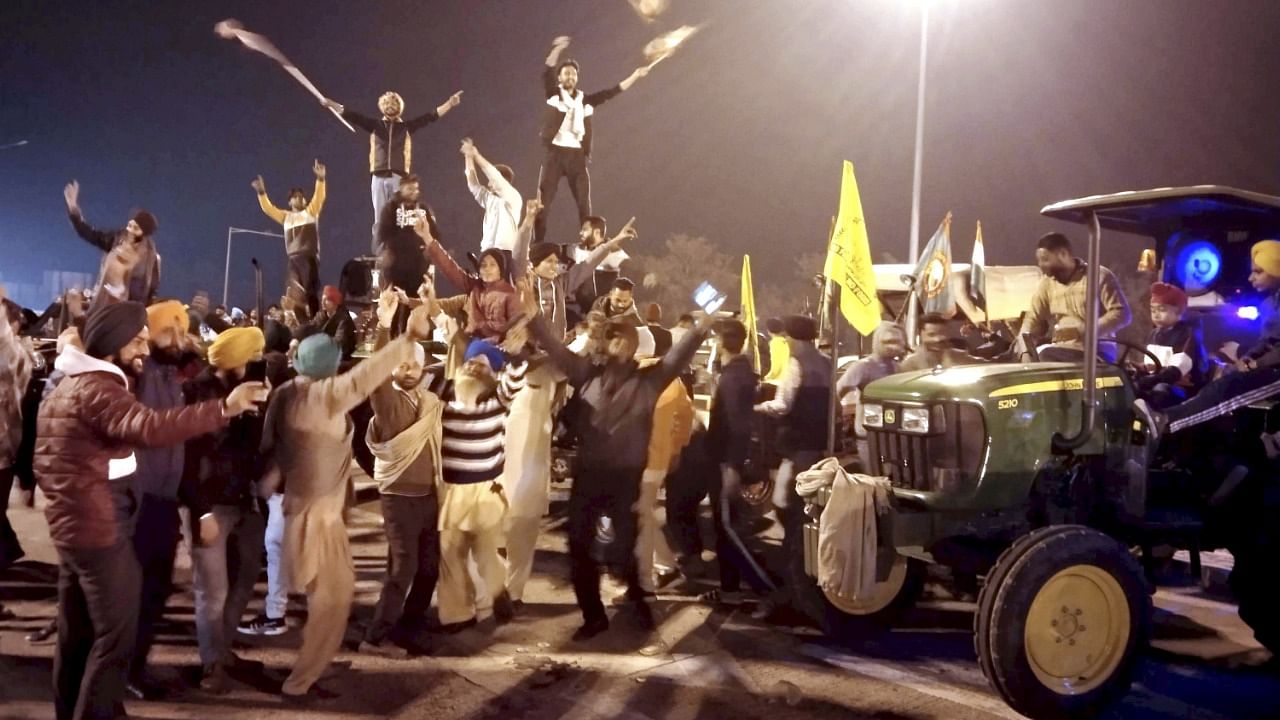 Farmers celebrate at the Delhi border. Credit: PTI Photo