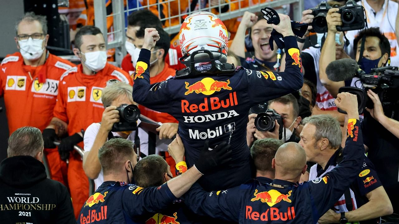 2021 FIA Formula One World Champion Red Bull's Dutch driver Max Verstappen celebrates with members of his team. Credit: AFP Photo