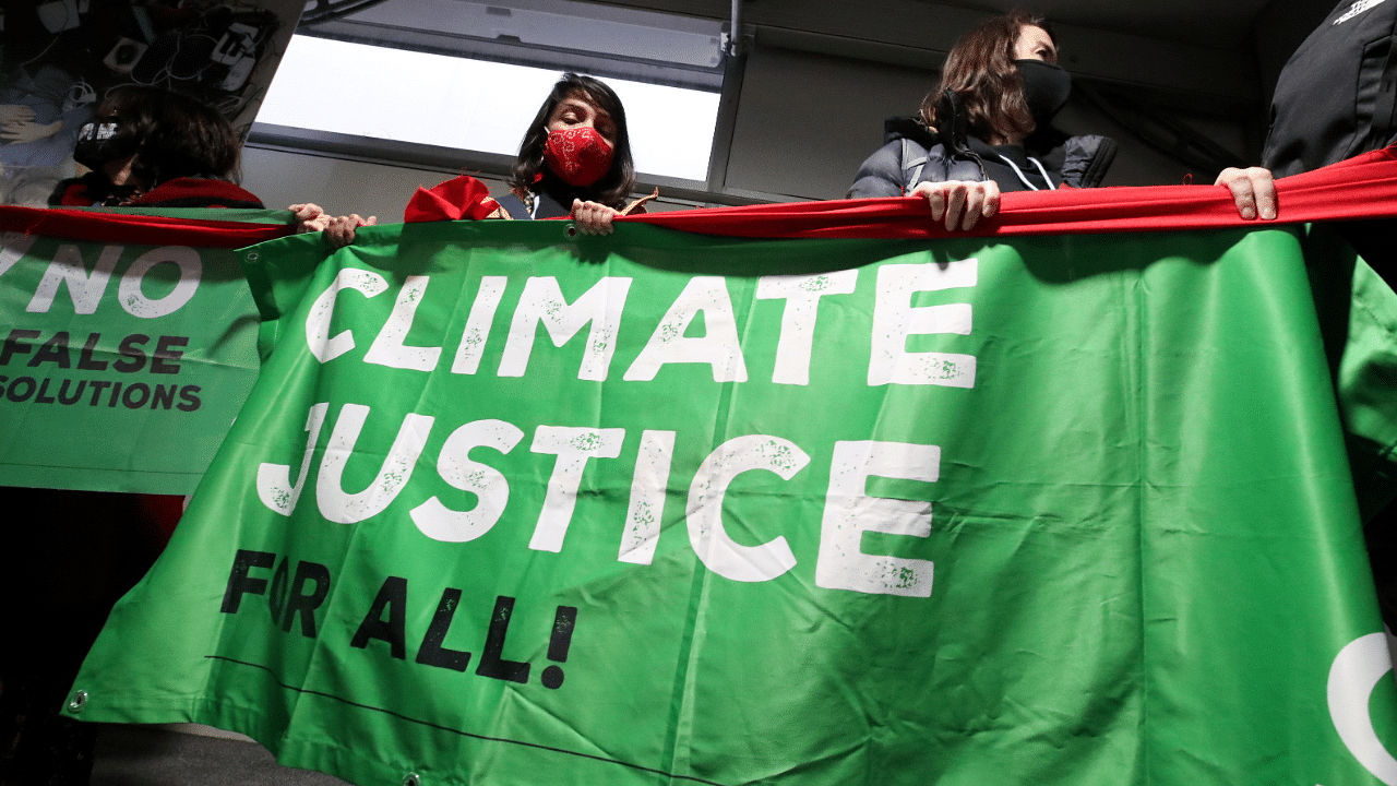 People hold a banner during a protest at the UN Climate Change Conference. Credit: Reuters Photo