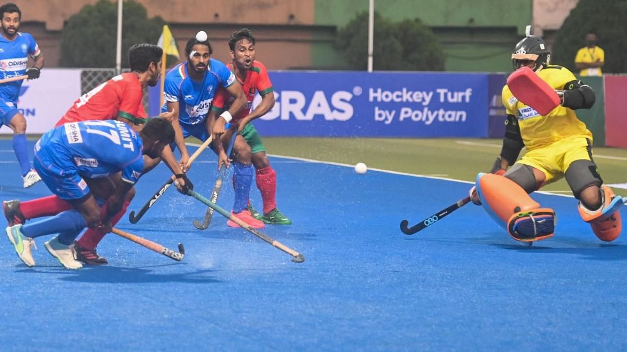 India's Sumit (L) takes a shot at the goal during the men's field hockey match between Bangladesh and India at the Asian Championship Trophy tournament in Dhaka. Credit: AFP Photo
