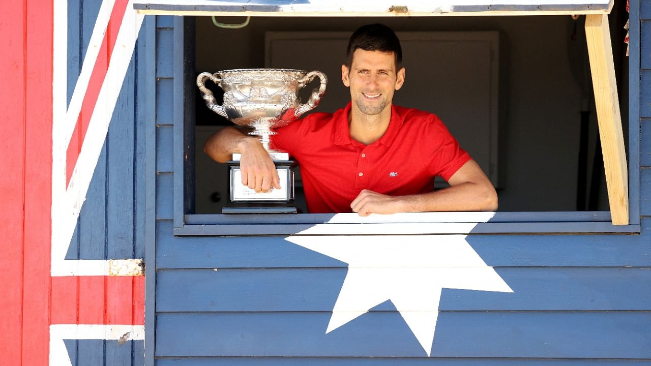 Australian Open champion Serbia's Novak Djokovic poses with the trophy during a photo shoot at Brighton Beach. Credit: Reuters Photo