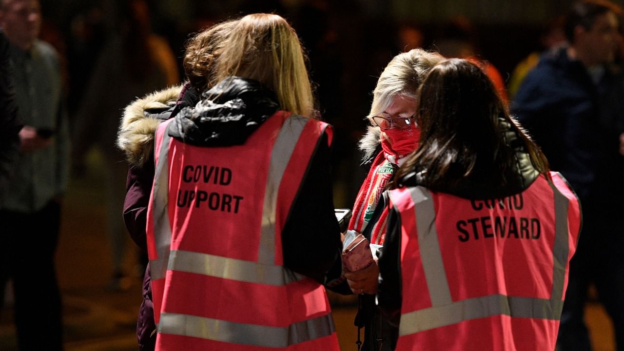 Supporters have their Covid-19 status checked by stewards as they arrive for the English Premier League football match between Liverpool and Newcastle United at Anfield in Liverpool, north west England on December 16, 2021. Credit: AFP Photo