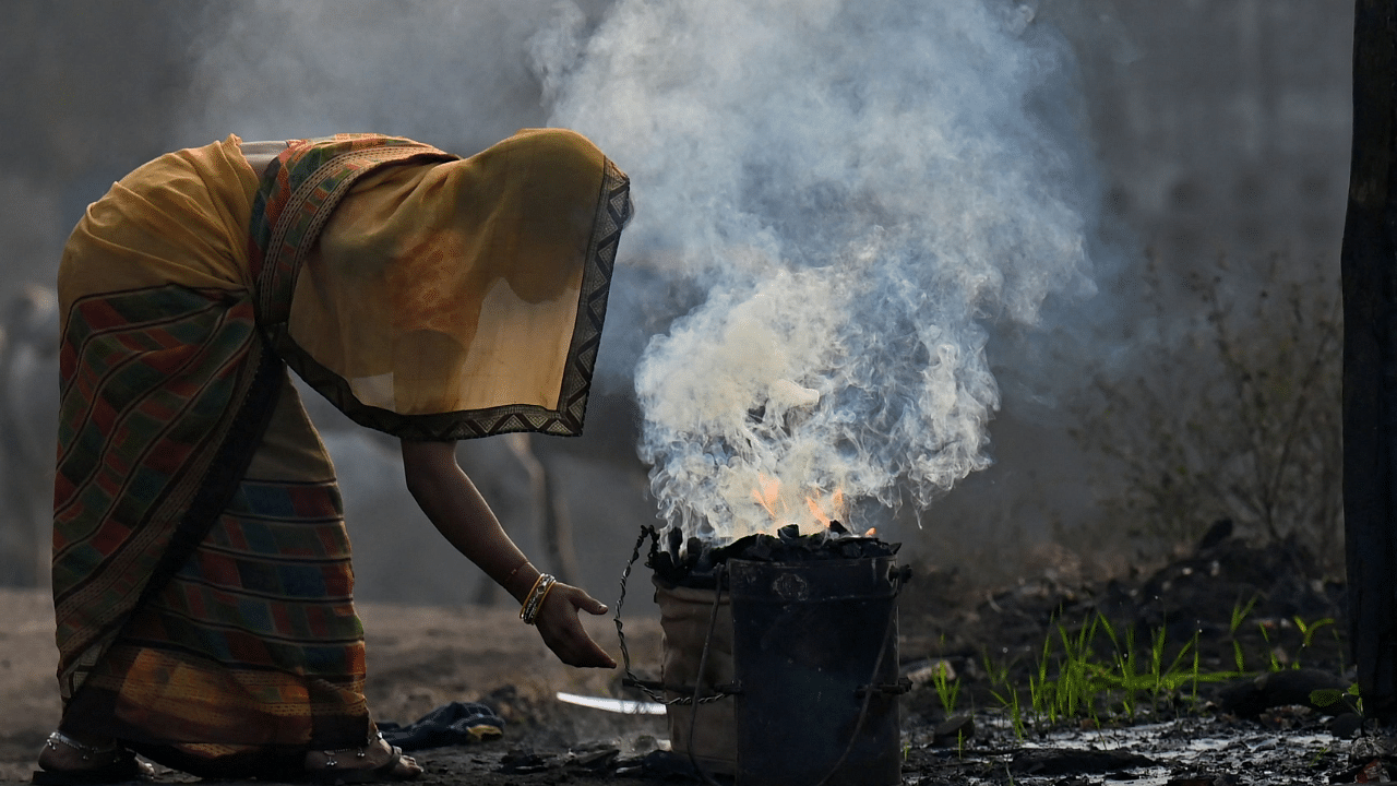 A woman burns coal for domestic use at Singrauli in Madhya Pradesh. Credit: AFP Photo