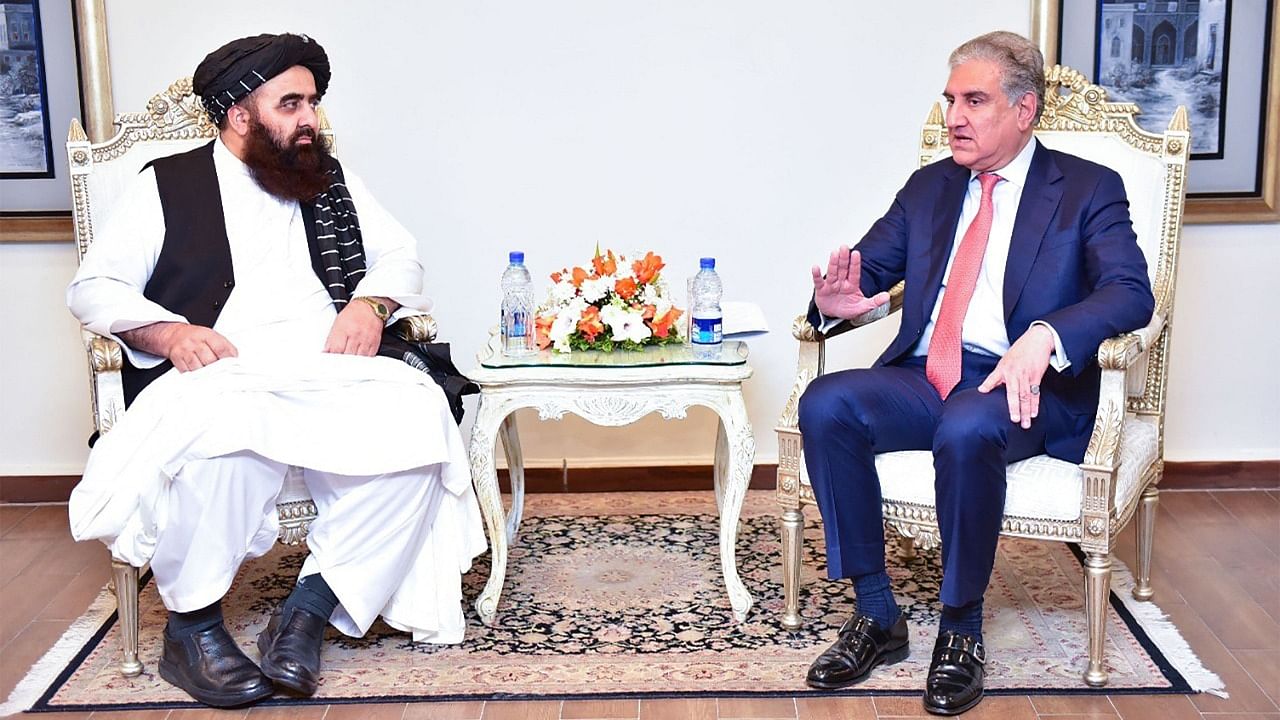 This handout photograph taken on December 18, 2021 and released by the Ministry of Foreign Affairs of Pakistan shows Pakistan's Foreign Minister Shah Mahmood Qureshi (R) speaking with Afghanistan's Taliban Foreign Minister Amir Khan Muttaqi during their meeting in Islamabad. Credit: AFP Photo