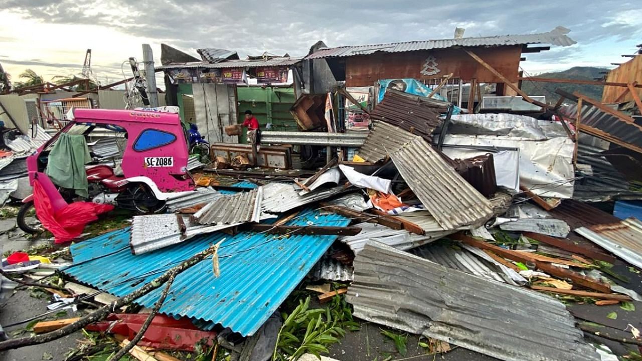 A resident salvaging belongings among debris caused by Super Typhoon Rai after the storm crossed over Surigao City in Surigao del Norte province. Credit: AFP Photo