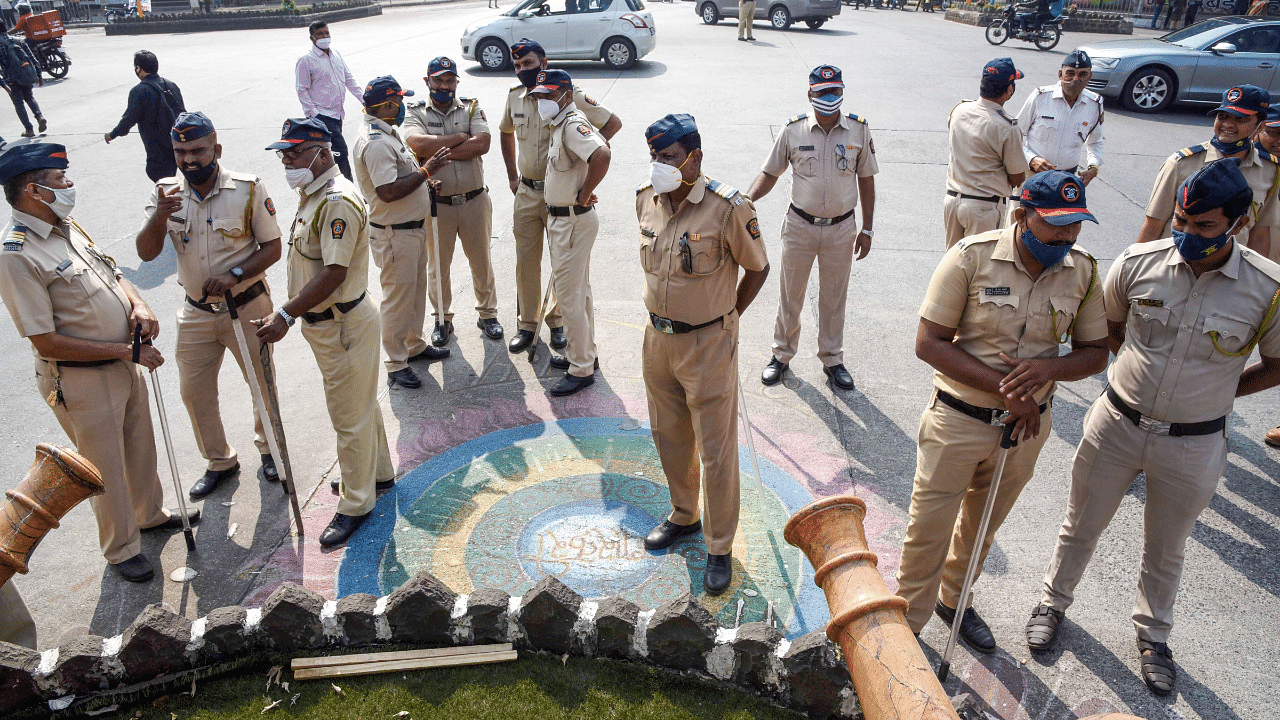 Police personnel stand guard as devotees stage a protest against Karnataka state government at Shivaji Maharaj Chowk, after some miscreants vandalised a statue of Shivaji Maharaj in Bengaluru. Credit: PTI Photo