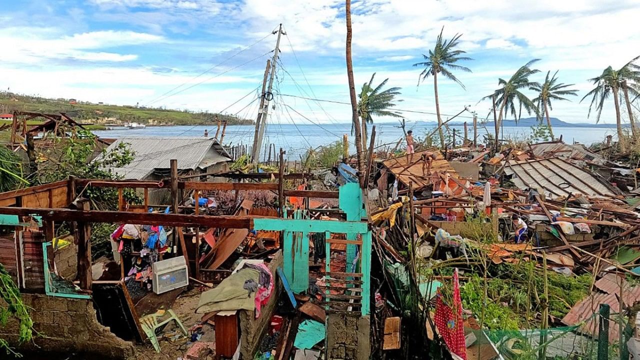Residents standing by their houses destroyed by Super Typhoon Rai. Credit: AFP Photo