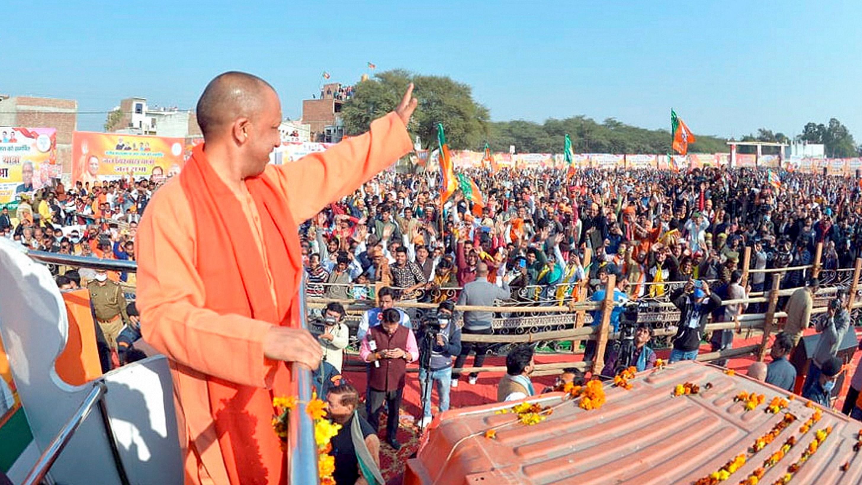 Uttar Pradesh Chief Minister Yogi Adityanath waves towards supporters during the inauguration of BJP's 'Jan Vishwas Yatra' ahead of the 2022 UP elections. Credit: Twitter/@myogiadityanath
