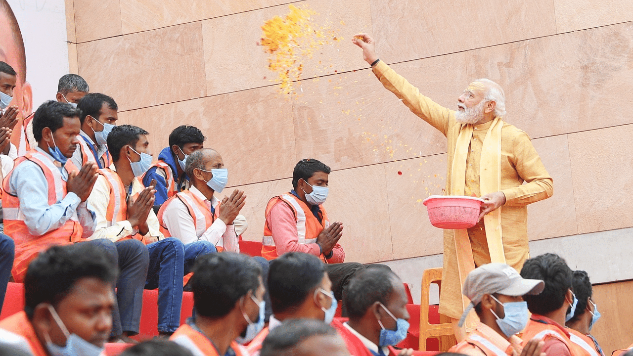 Prime Minister Narendra Modi showers flower petals on the workers involved in construction work of Kashi Vishwanath Dham Corridor in Varanasi. Credit: IANS Photo