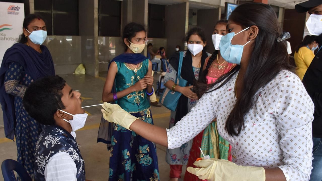 A health worker collecting swab samples in Bengaluru on Monday. Credit:DH Photo/BK Janardhan