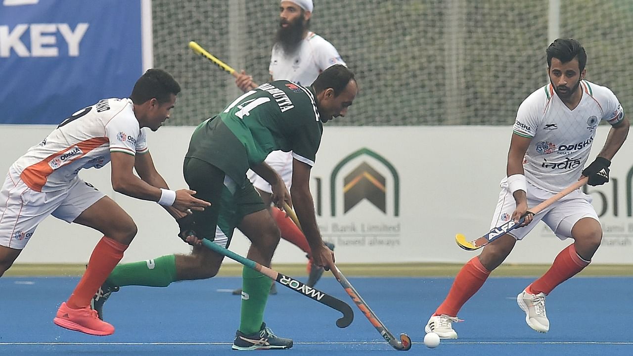 Pakistan's Umar Bhutta (C) and India's Shilanand Lakra (L). Credit: AFP Photo