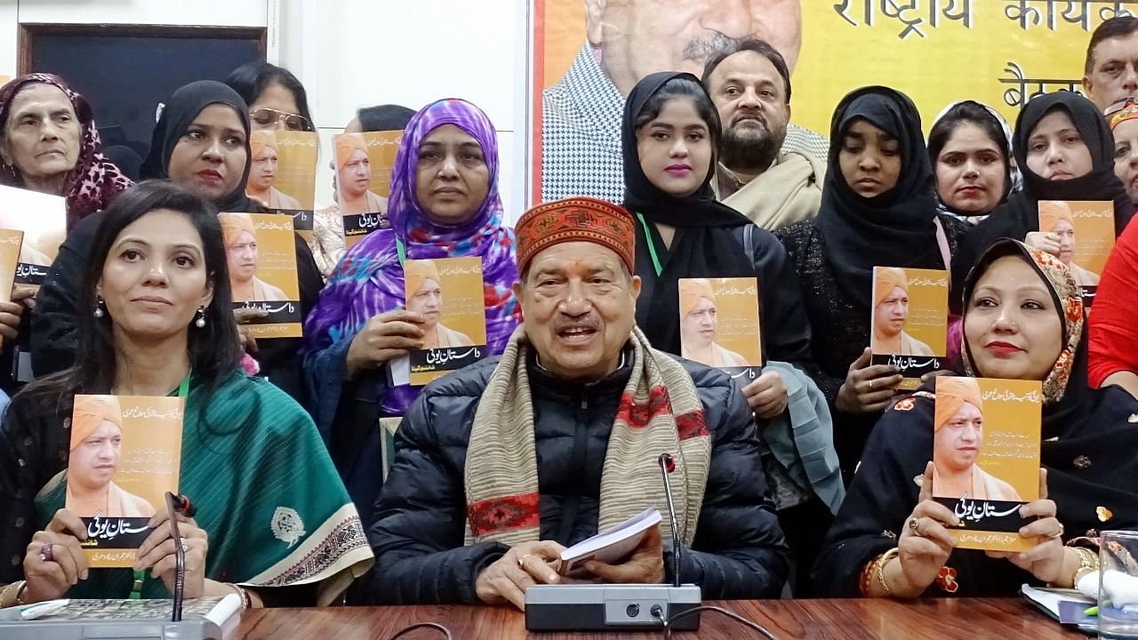 Indresh Kumar along with women members of Muslim Rashtriya Manch releases a biography of UP CM Yogi Adityanath in Urdu. Credit: PTI Photo