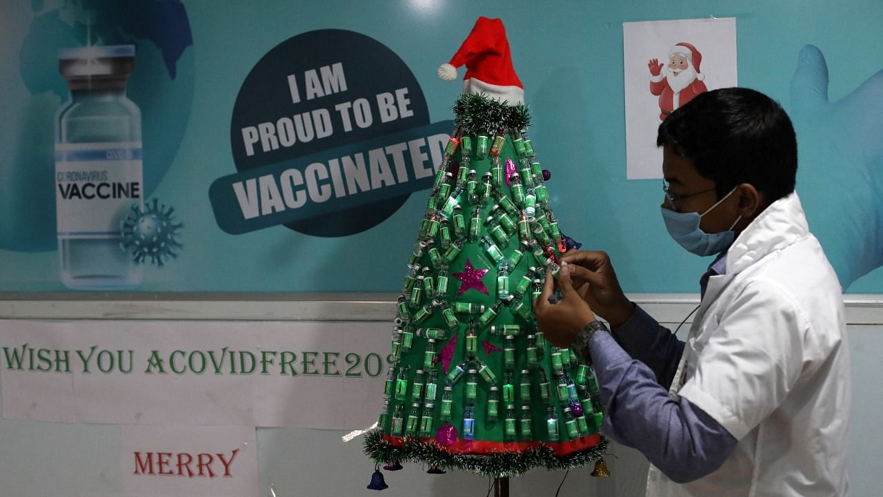 Healthcare worker decorates Christmas tree with empty vials of Covid-19 vaccine, in Kolkata. Credit: Reuters Photo