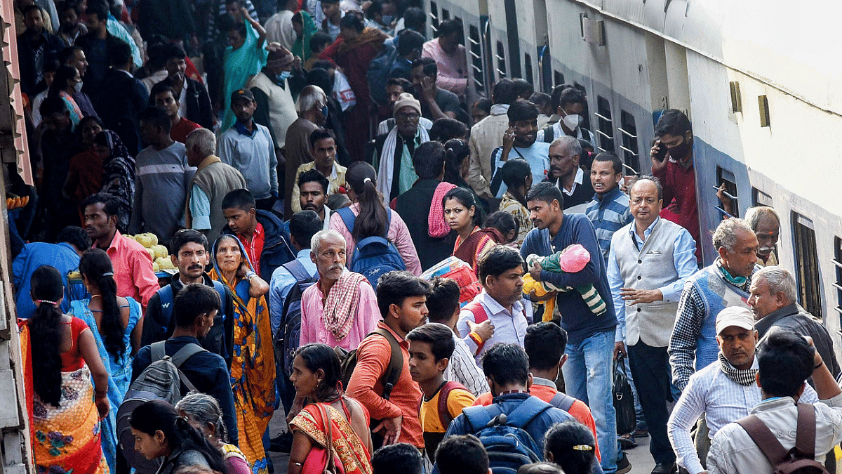 Passengers not adhering to social distancing norms board a train at a railway station, amid possible spread of Omicron variant of Covid-19, in Patna. Credit: PTI Photo