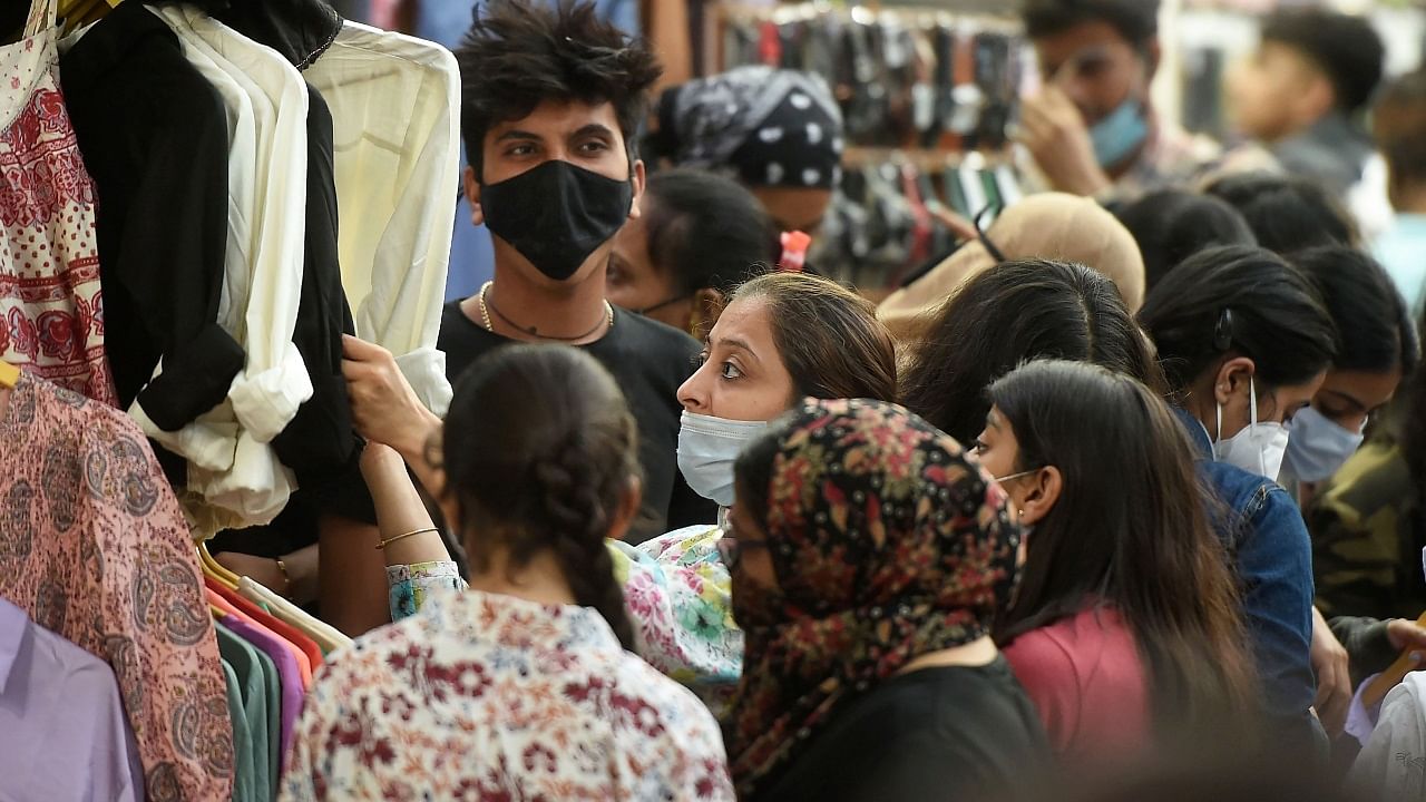 People wearing masks in improper way, shop at a market at Bandra in Mumbai. Credit: PTI Photo