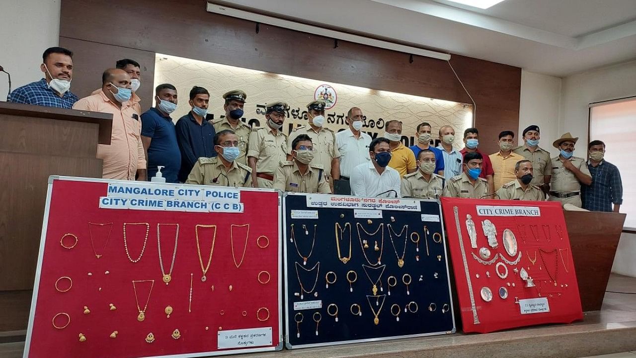 Mangaluru Commissioner of Police N Shashi Kumar with the valuables worth over Rs 40 lakh seized from four notorious burgles at Commissioner's hall in Mangaluru on Thursday. Credit: DH Photo
