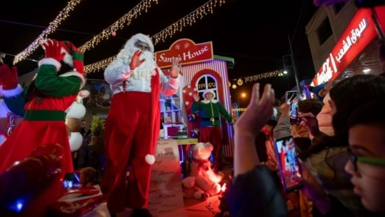 Performers are seen during the annual Christmas caravan parade in the West Bank city of Bethlehem, on Dec. 19, 2021. Credit: IANS Photo