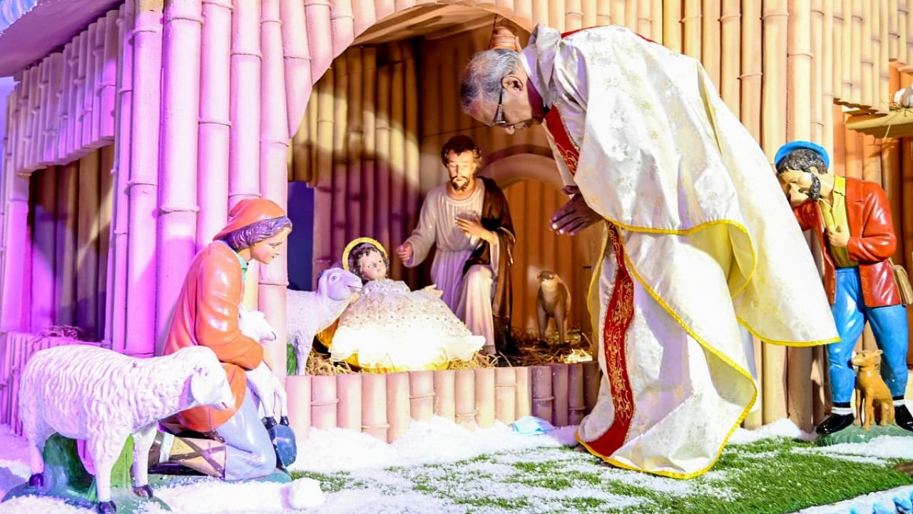 Fr Martin Kumar places infant Jesus in the crib at St Mary’s Basilica in Shivajinagar on Christmas eve. Credit: DH Photo/M S Manjunath