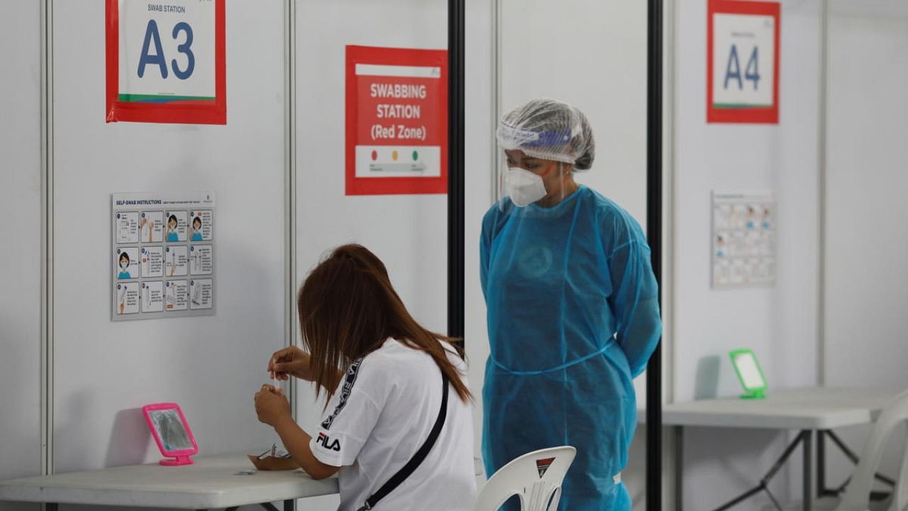 A woman takes her antigen rapid test under supervision at a Quick Test Centre in Singapore. Credit: Reuters file photo