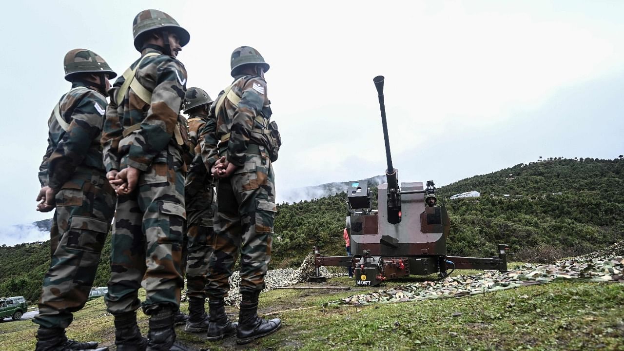 Indian Army soldiers stand next to an upgraded L70 anti aircraft gun in Tawang near the Line of Actual Control (LAC), in Arunachal Pradesh. Credit: AFP File Photo