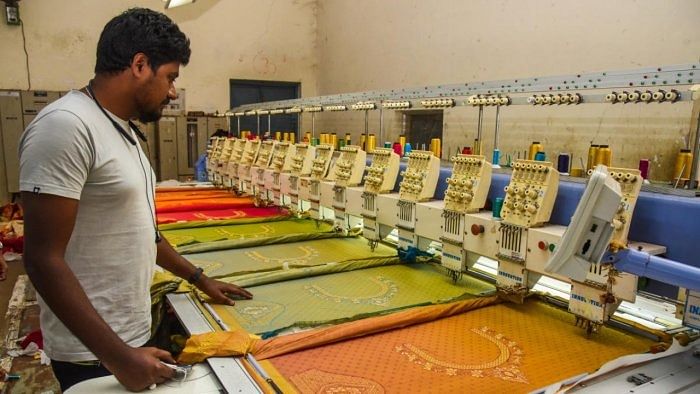 File Photo of a weaver carrying out embroidery work on a saree at a powerloom unit. Credit: DH Photo