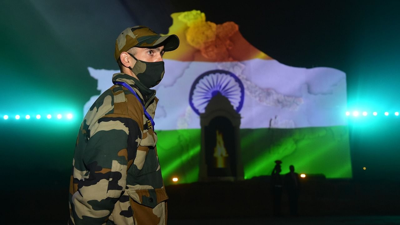 A soldier stands guard during the sound and light show to celebrate 'Swarnim Vijay Parv', the 50th anniversary of the 1971 war victory, near India Gate in New Delhi. Credit: PTI File Photo