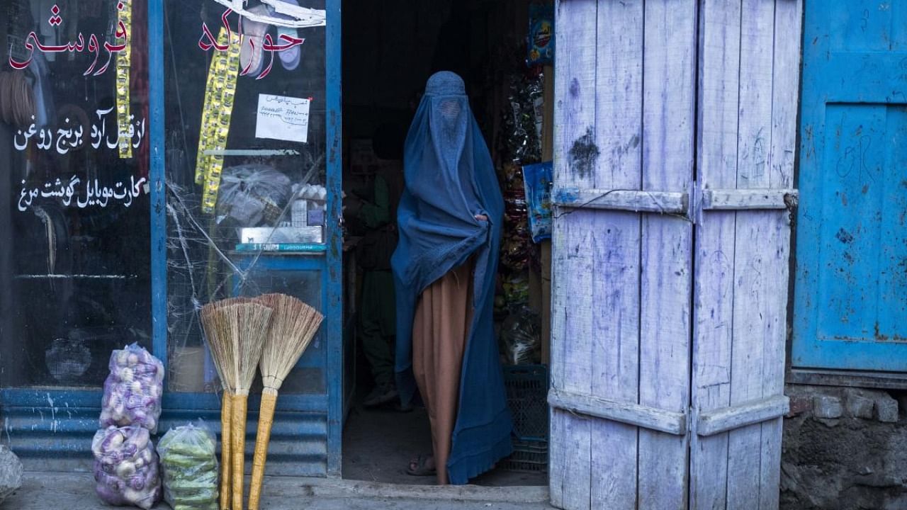 An Afghan woman wearing a burka exits a small shop in Kabul, Afghanistan. Credit: AFP file photo
