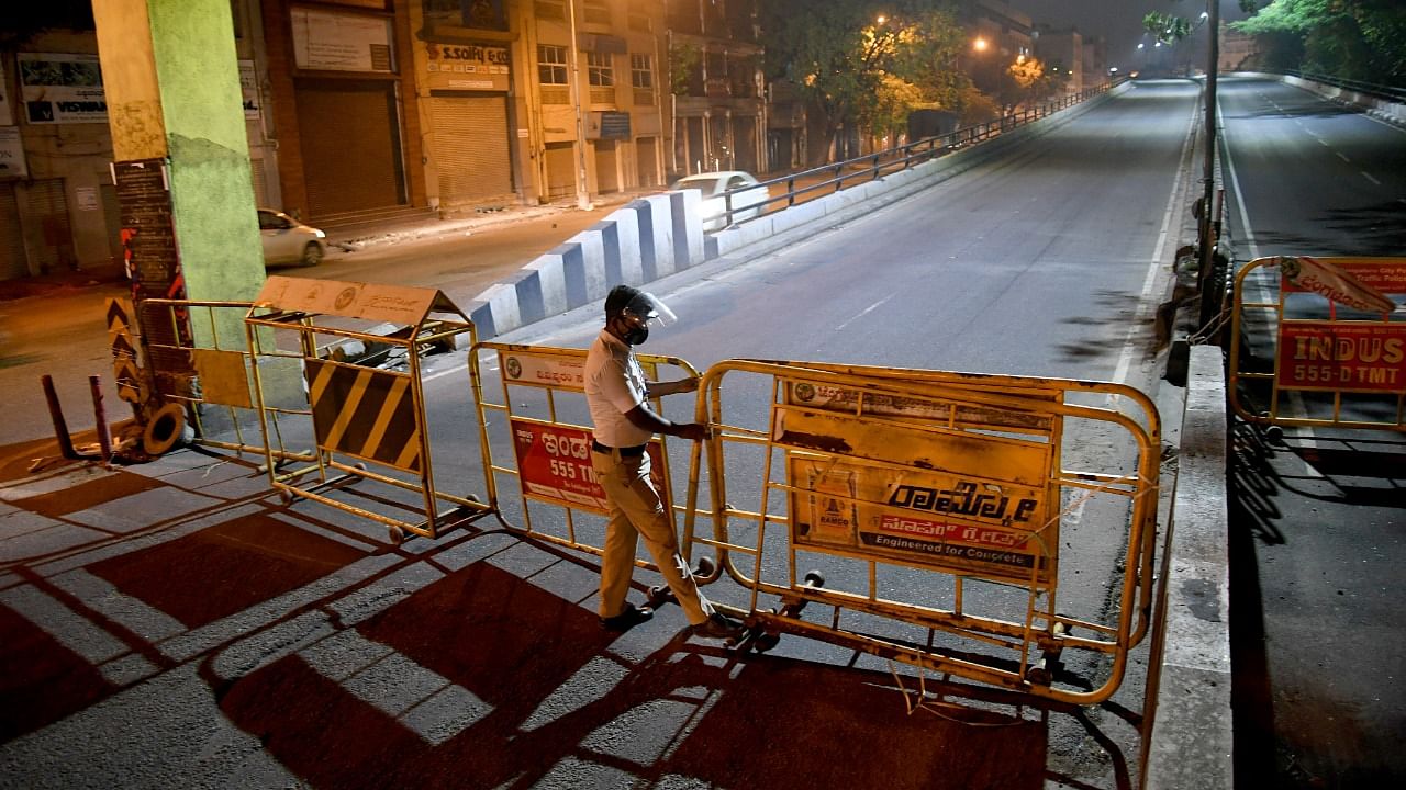 A file picture of a policeman setting up barricades during the night curfew earlier this year. Credit: DH File Photo/Puskar V