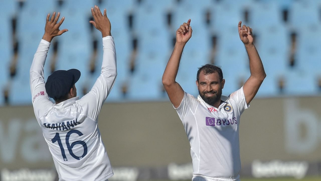 India's Mohammed Shami (R) celebrates with teammate Mayank Agarwal after the dismissal of South Africa's Kagiso Rabada (not seen) during the third day of the first Test at SuperSport Park in Centurion. Credit: AFP Photo