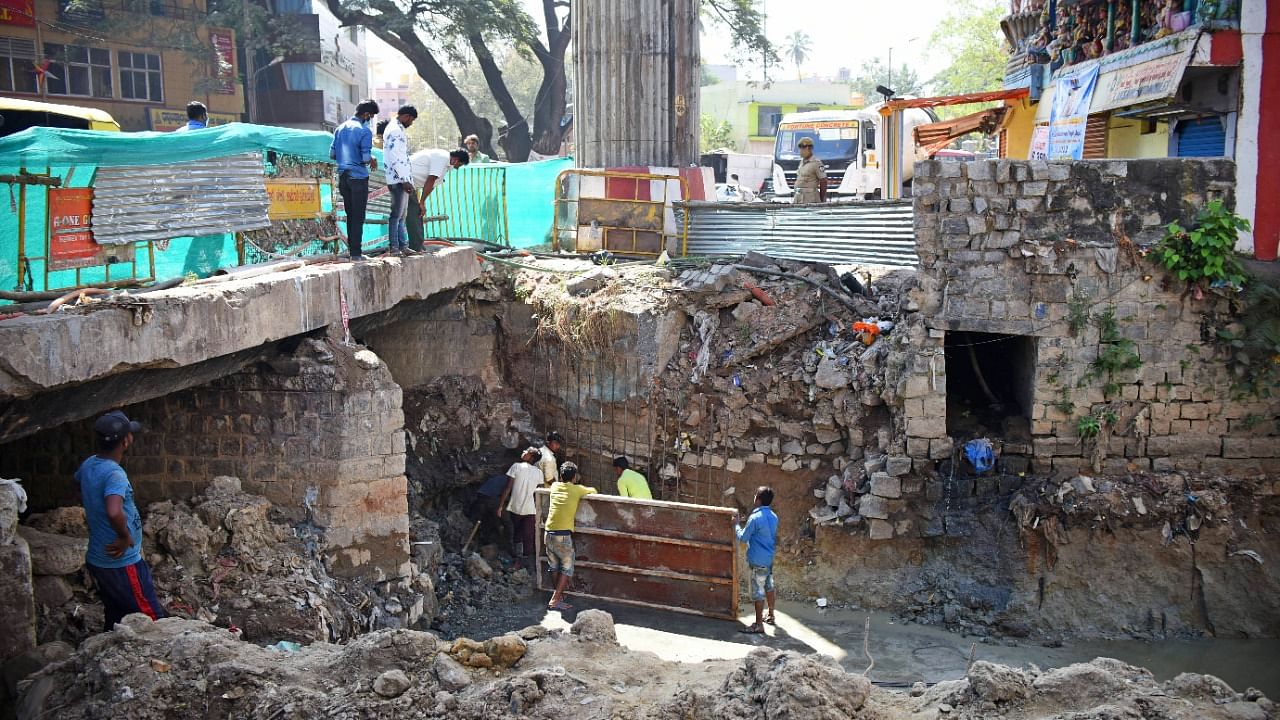 Workers at the storm water drain in Halasuru where remodelling work exposed the base of pillar 109A on Tuesday. Credit: DH Photo/Pushkar V