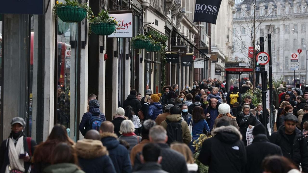 Shoppers, some wearing a facemask to combat the spread of Covid-19, walk along Regent Street in London. Credit: AFP Photo