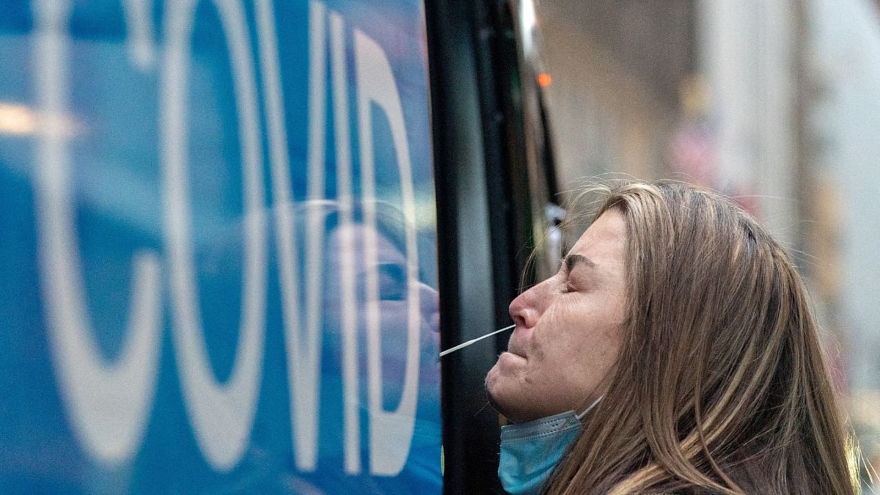 A woman takes a Covid-19 test at a pop-up testing site as the Omicron coronavirus variant continues to spread in Manhattan, New York City. Credit: Reuters File Photo