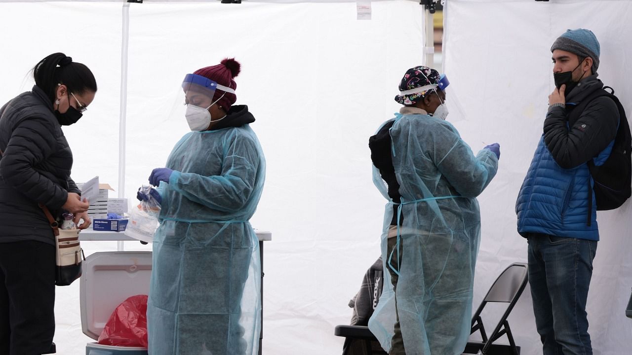  Healthcare workers administer Covid-19 PCR test at a free test site in Farragut Square on December 28, 2021 in Washington, DC. Credit: AFP Photo