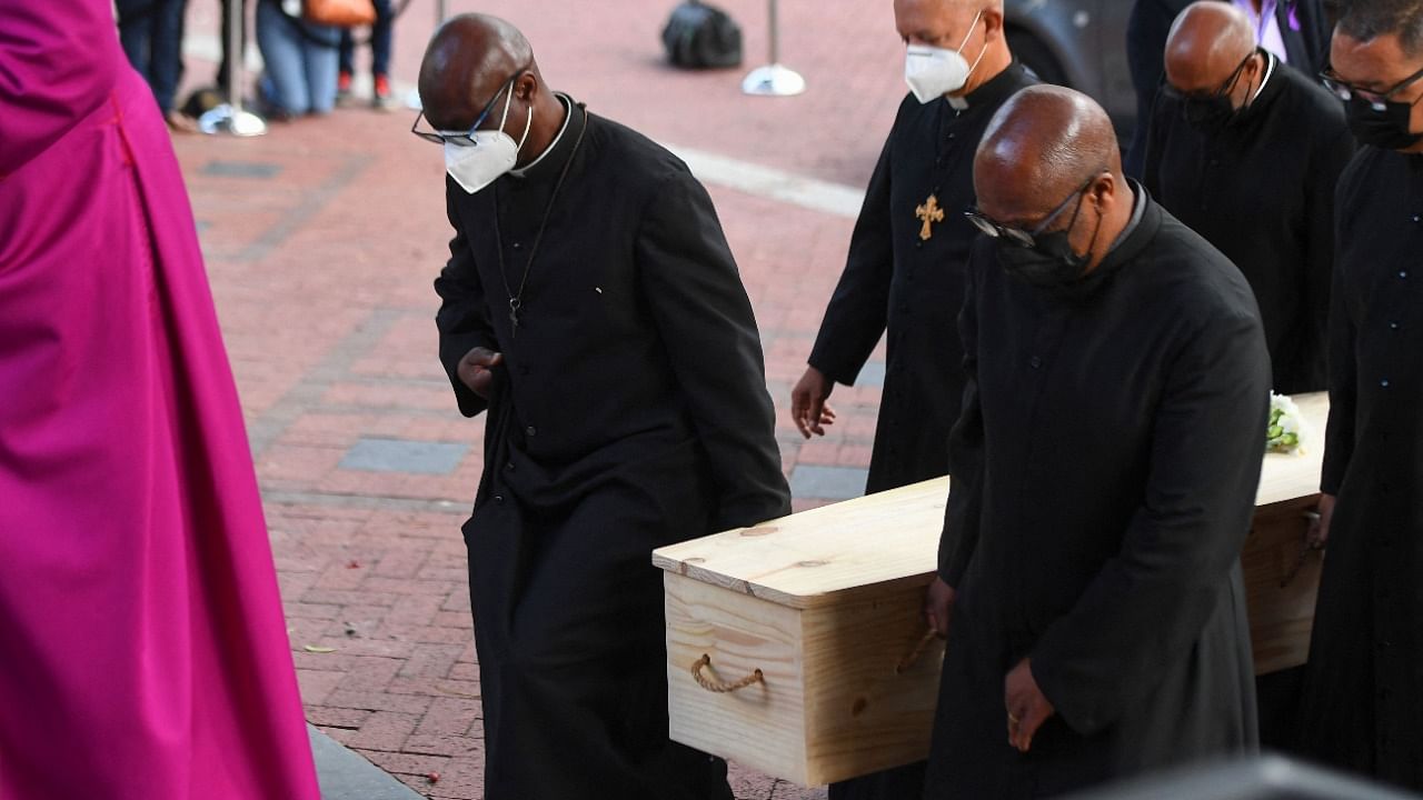 Archbishop of Cape Town stands next to the casket containing the body of Archbishop Desmond Tutu during arrival at St George's cathedral. Credit: AFP Photo