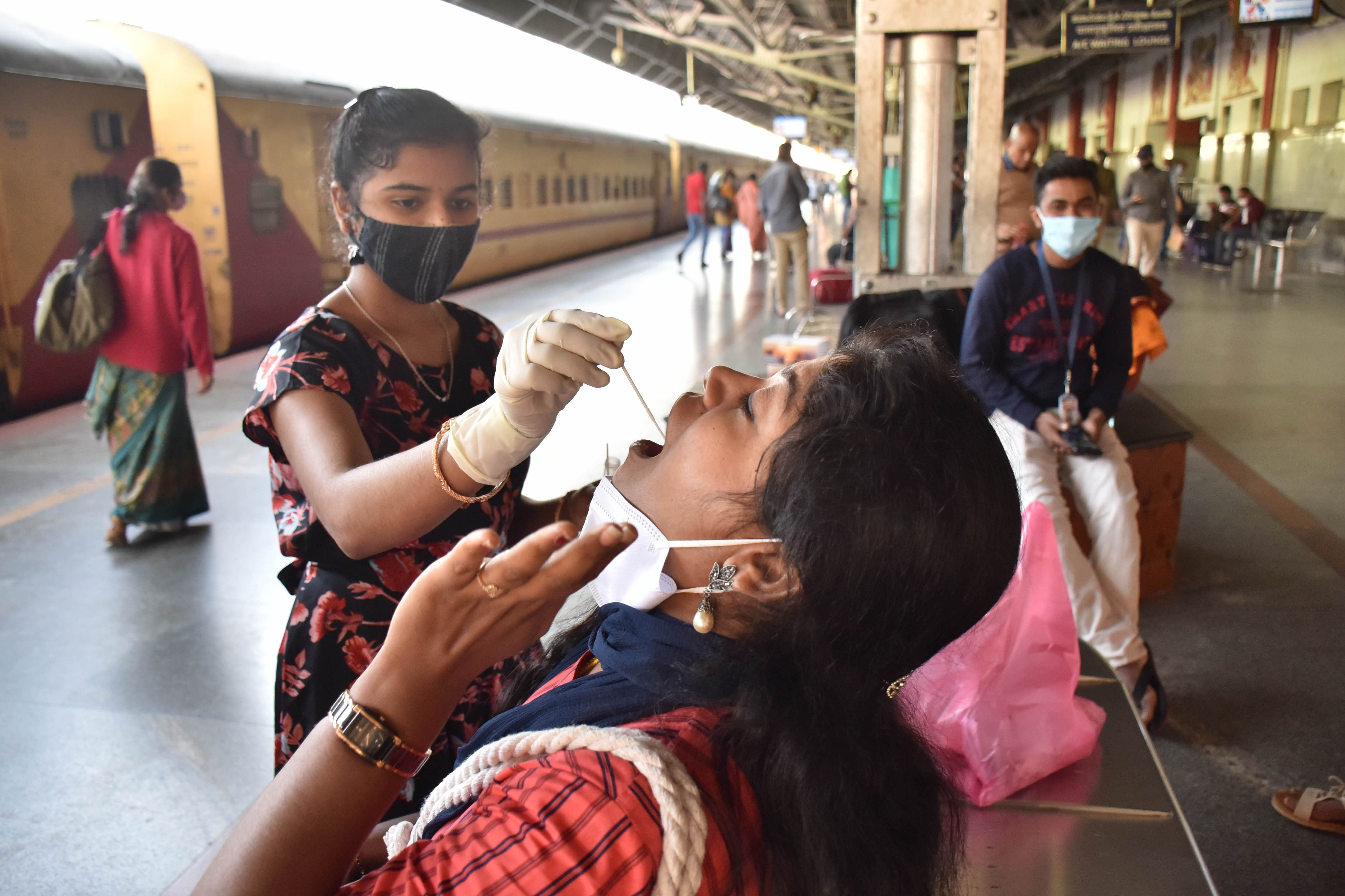 A health worker collects Covid-19 samples from passengers at KSR Railway Station in Bengaluru. Credit: DH File Photo/B K Janardhan