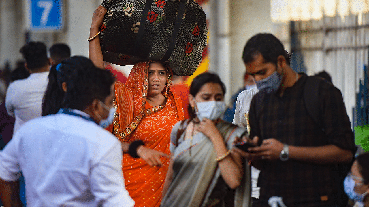 Passengers wearing face masks as a precaution against coronavirus arrive at Dadar railway station. Credit: PTI Photo