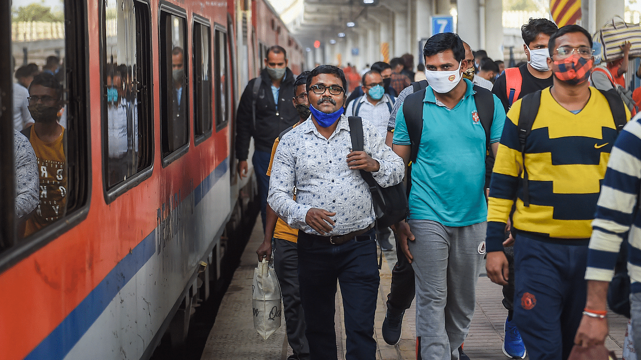 Passengers wearing face masks as a precaution against coronavirus arrive at Dadar railway station. Credit: PTI Photo