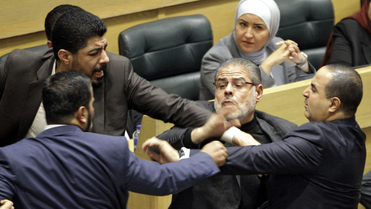 Jordanian parliament members are separated during an altercation in the parliament in the capital Amman. Credit: AFP Photo