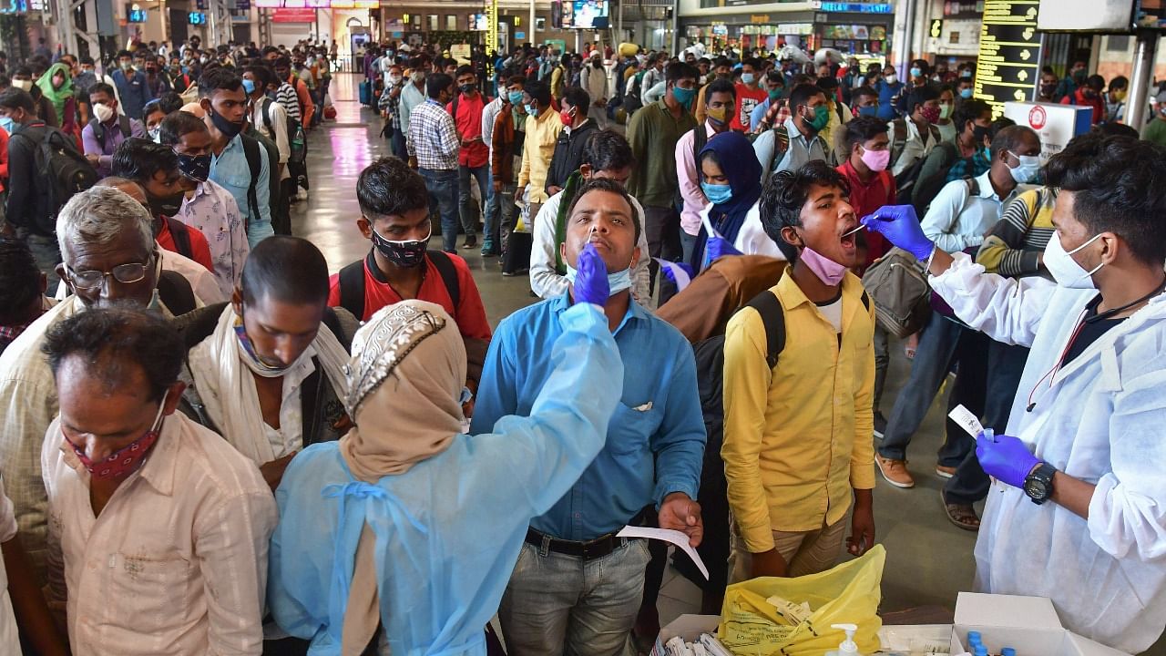 A Brihanmumbai Municipal Corporation (BMC) health worker collects swab samples of an outstation passenger for Covid-19 test, at CSMT railway station in Mumbai. Credit: PTI Photo